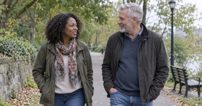 Adult couple talking while walking together on a neighborhood park path.