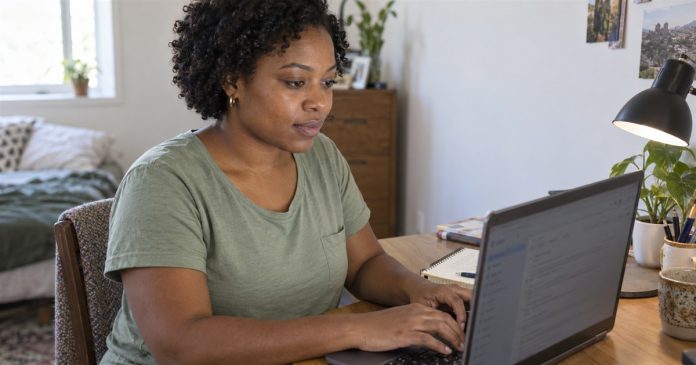 Woman using a laptop to follow an email-reading request at a small home desk.