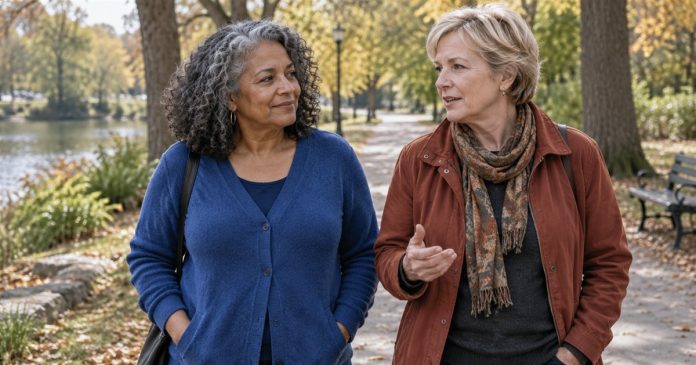 Two adult friends talking during a relaxed walk on a neighborhood park path.