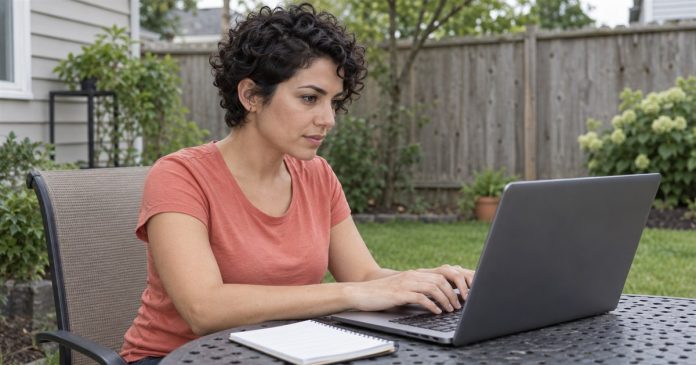 Woman composing a first email-reading question on a laptop at a modest backyard table.